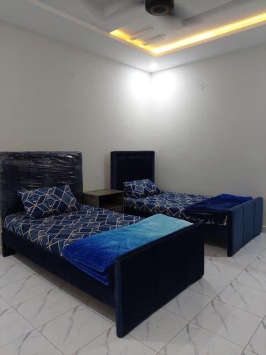 伊斯兰堡Comfy stays near Islamabad airport的配有蓝色床单的客房内的两张床