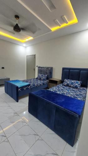 伊斯兰堡Comfy stays near Islamabad airport的配有蓝色床单的客房内的两张床