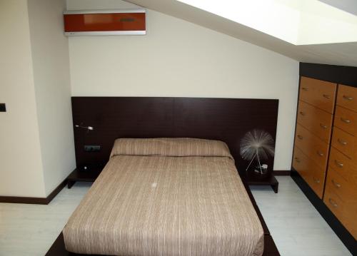 莱斯卡瑟斯-达尔卡纳Sealand Apartment的一间卧室配有一张大床和棕色床头板