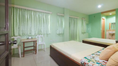 CabatuanCM Apartelle Iloilo International Airport by RedDoorz的一间卧室配有两张床和一张桌子