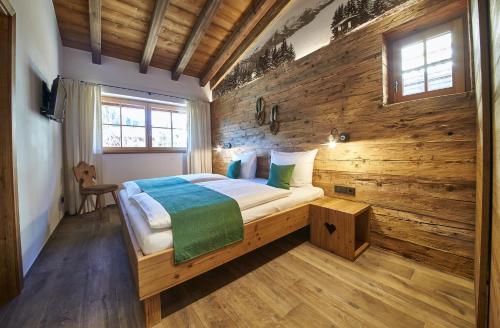 萨尔巴赫Panorama Chalets的一间卧室设有木墙,配有一张床