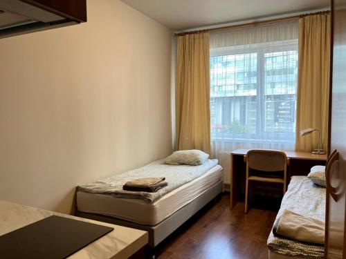 里加RVR Smart Apartments Riga with self Check-in的客房设有两张床、一张桌子和一个窗户。