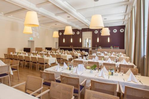 贝尔吉施格拉德巴赫卡迪纳尔舒尔特豪斯酒店的宴会厅配有白色的桌椅