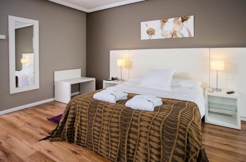 阿拉贡省阿拉马阿拉贡省巴尔内阿里奥阿拉马酒店的一间卧室配有一张大床和两条毛巾