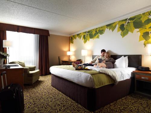 埃德蒙顿怀特瓦斯科纳酒店的坐在酒店房间床上的男女