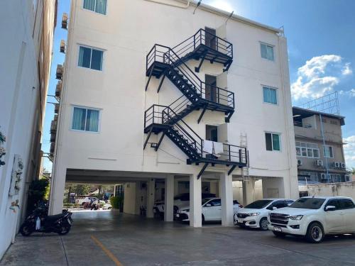 乌隆他尼Tisa Hotel Udonthani的停车场内有楼梯的大型白色建筑