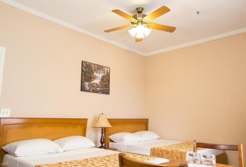 乔治敦圭亚那INC.德班酒店的一间卧室配有两张床和吊扇