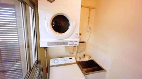 怀希怀希海汽车旅馆 的厨房配有洗衣机和水槽