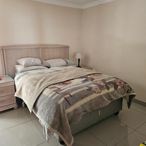 逊邱伦Marigold Self Catering Apartment的一间卧室配有一张带毯子的大床
