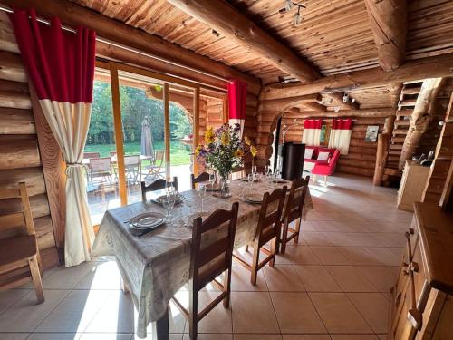 Nuisement-sur-CooleC Les rondins nature gîte 8 personnes avec jardin的一间带长桌和椅子的用餐室