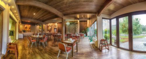 科扎尼塞里可斯酒店的用餐室配有桌椅和大窗户