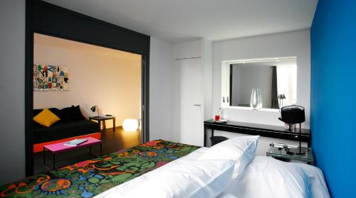 圣索旺弗兰克斯佳客思设计酒店的一间卧室配有一张床、一张沙发和一面镜子