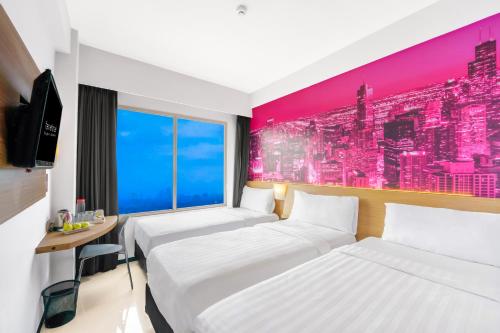 泗水泗水容库喜爱酒店的一间酒店客房,设有两张床和电视