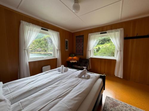 弗洛姆Svingen Guesthouse - Panoramic Fjord Views in Flåm的一间卧室设有一张大床和两个窗户。