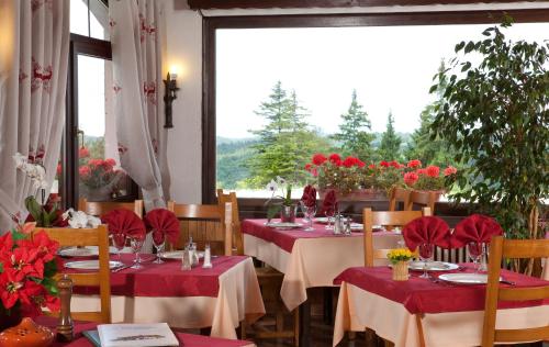 热克斯Logis Hôtel La Petite Chaumière的一间设有红色桌布的餐桌的用餐室