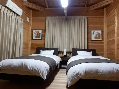 京都宿屋三坊度假屋的木墙客房的两张床