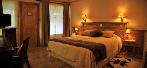 La JuntaEspacio y Tiempo Hotel de Montaña的一间卧室配有一张大床和电视