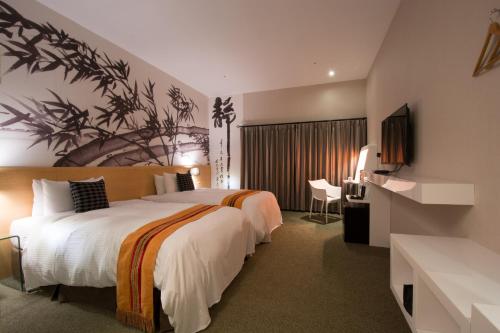 嘉义市嘉义行艺文旅的酒店客房设有一张大床和一台电视。