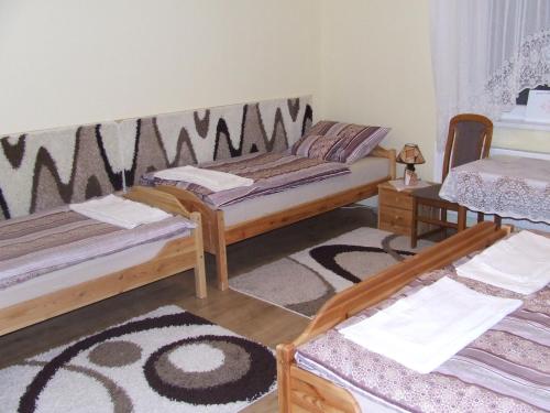 NyírmeggyesMeggyes Vendégház的客厅配有两张床和地毯。