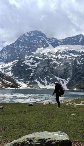 Nikri DhokriNatural Meadows Kashmir的背着背包的人站在山边的田野里