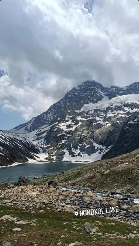 Nikri DhokriNatural Meadows Kashmir的山间,前方有湖泊