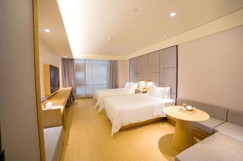 花都Ji Hotel Guangzhou Baiyun Airport的酒店客房,设有两张床和一张沙发