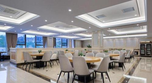 长沙Vienna Hotel Hunan Changsha Gaoling的一间会议室,配有桌椅和窗户