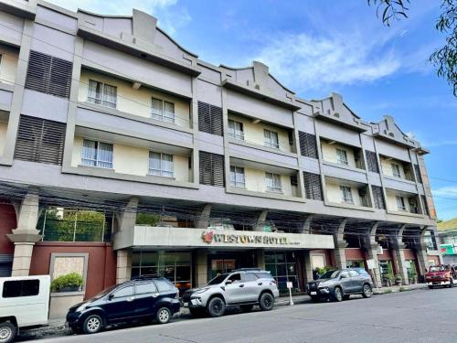 巴科洛德MO2 Westown Hotel San Juan的一座大型建筑,前面有汽车停放