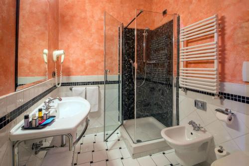 罗马旧金山酒店的一间带水槽、淋浴和卫生间的浴室
