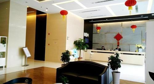 泉州Metropolo Hotel Jinjiang Wudian Wanda Plaza的大堂,有柜台,有镜子的人