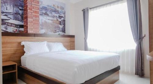 玛琅Noura Guest House Syariah的卧室配有一张大白色床和窗户