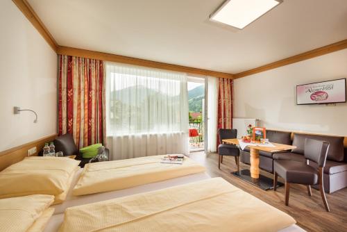 巴特霍夫加施泰因阿尔本霍夫酒店的酒店客房设有两张床和一张桌子。