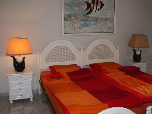 福恩吉罗拉Villa Bonita Fuengirola的一间卧室配有一张床和两个带灯的床头柜