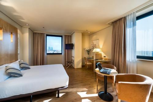 马德里阿巴马德里酒店的酒店客房配有一张床、一张书桌和一台笔记本电脑