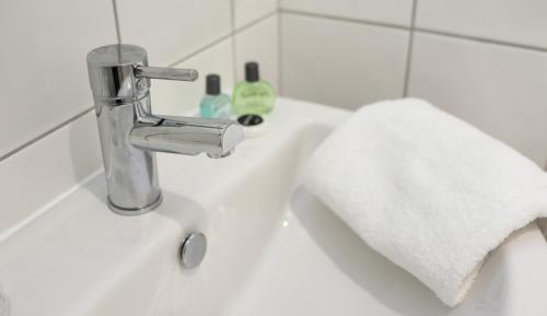 谢珀顿沃伦旅舍的浴室水槽配有水龙头和毛巾