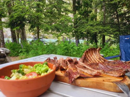 特来凡林Patagonia glamping rio grande的盘带肉和一碗沙拉的食物