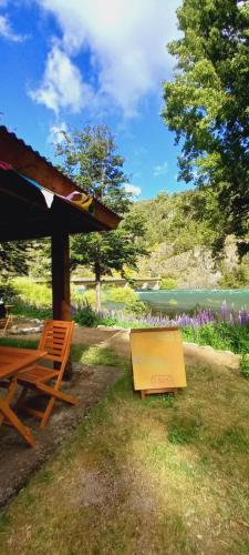 特来凡林Patagonia glamping rio grande的湖畔野餐桌和长凳