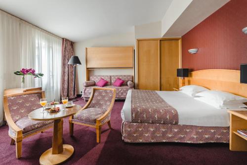 巴黎巴士底天井酒店的酒店客房带一张床、一张桌子和椅子