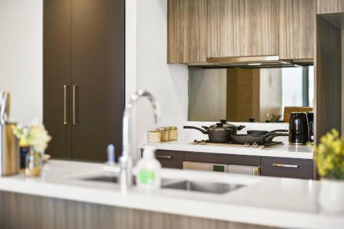 悉尼2BR Luxury Stay in Ultimo的厨房配有水槽和炉灶 顶部烤箱