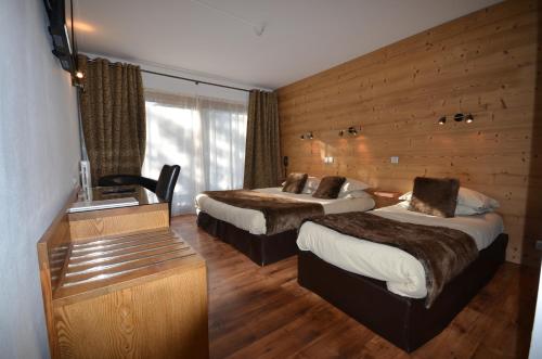 布里昂松艾德维斯酒店的酒店客房配有两张床和一张书桌