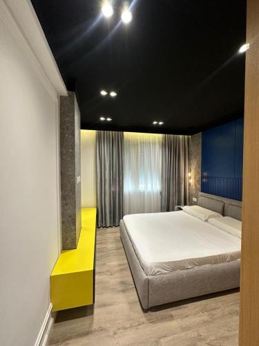 圣金Escape Luxury Apartment 2 Shengjin的一间卧室设有一张大床和一张黄色长凳