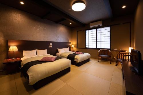 别府旅亭松叶屋的酒店客房设有两张床和电视。
