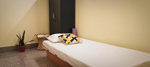 王舍城Nikunj Dorme的一间卧室配有一张带两个枕头的床