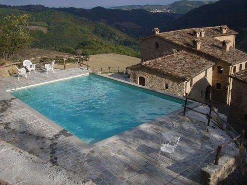 Macerata Feltria西斯特纳古老村庄酒店的房屋前的大型游泳池