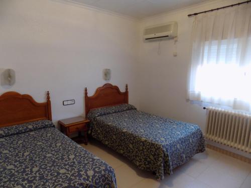 奥卡尼亚朋友旅馆的酒店客房设有两张床和窗户。