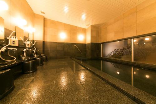 一宫市AB一宫酒店 的大型浴室设有游泳池和卫生间
