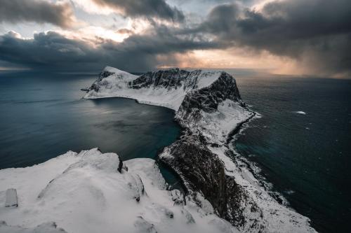 VærøyLofoten Fyr的冰山在海洋上积雪