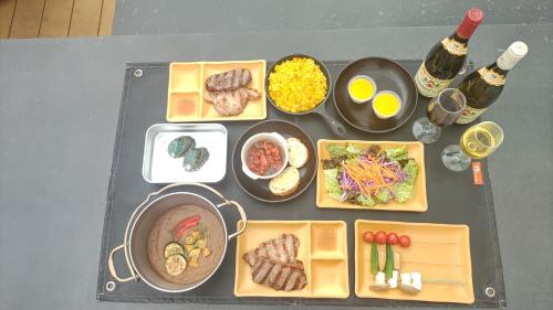 IsumiISUMI Glamping Resort ＆Spa SOLAS的一张桌子,上面放着食物和葡萄酒