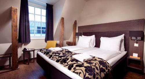 海宁格松Banken Hotel的一间卧室配有一张大床,提供黑白毯子