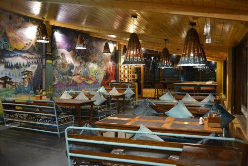 马拉里Hotel Neelgiri - Manali Diaries的餐厅设有桌椅和吊灯。